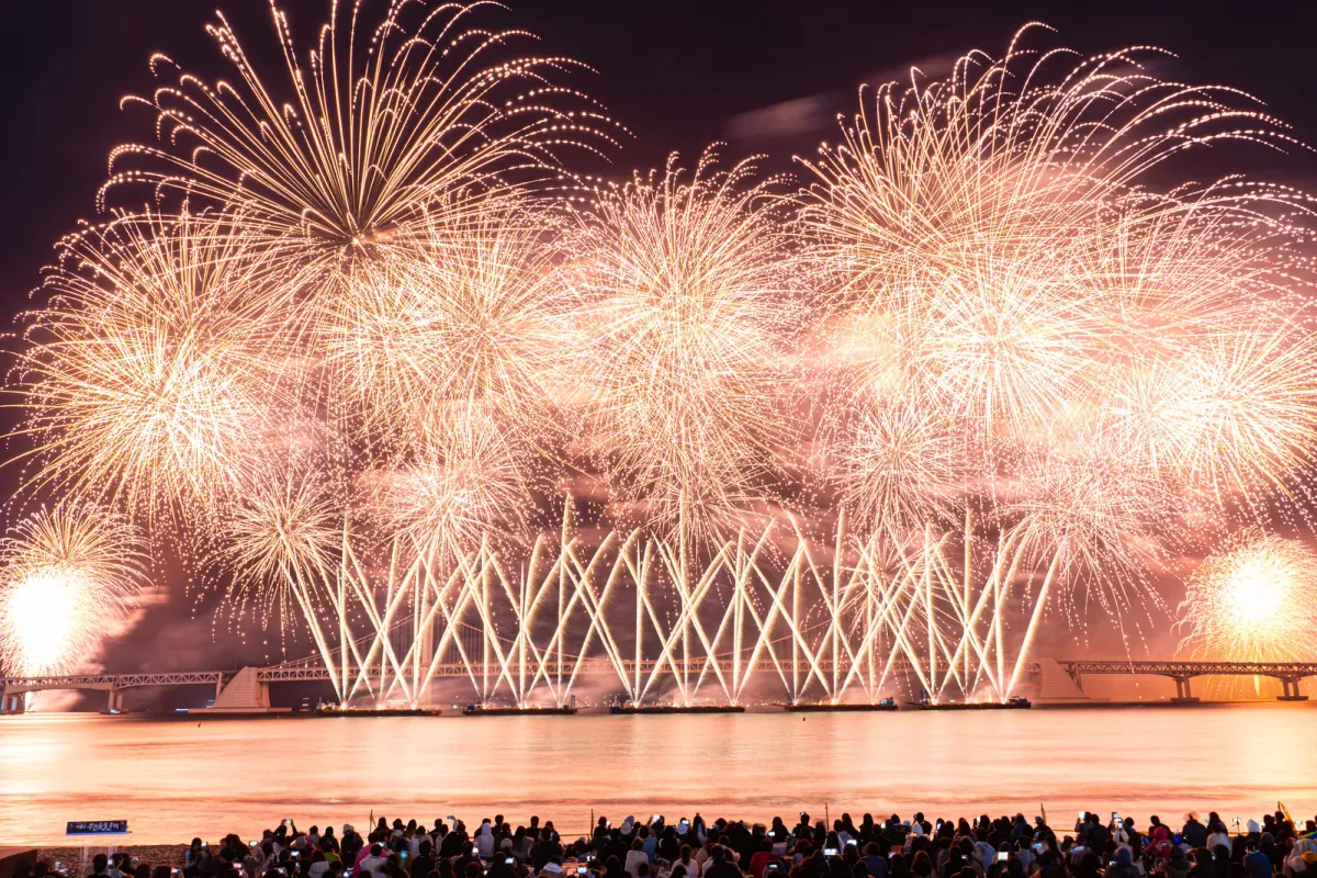 Crowds on Gwangalli Beach watching fireworks over Gwangan Bridge head-on