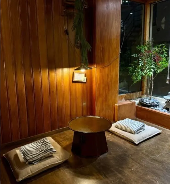 Gojae's floor seating area with wood-paneled interior