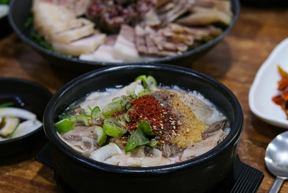 A steaming bowl of Korean gukbap, pork broth soup served over rice