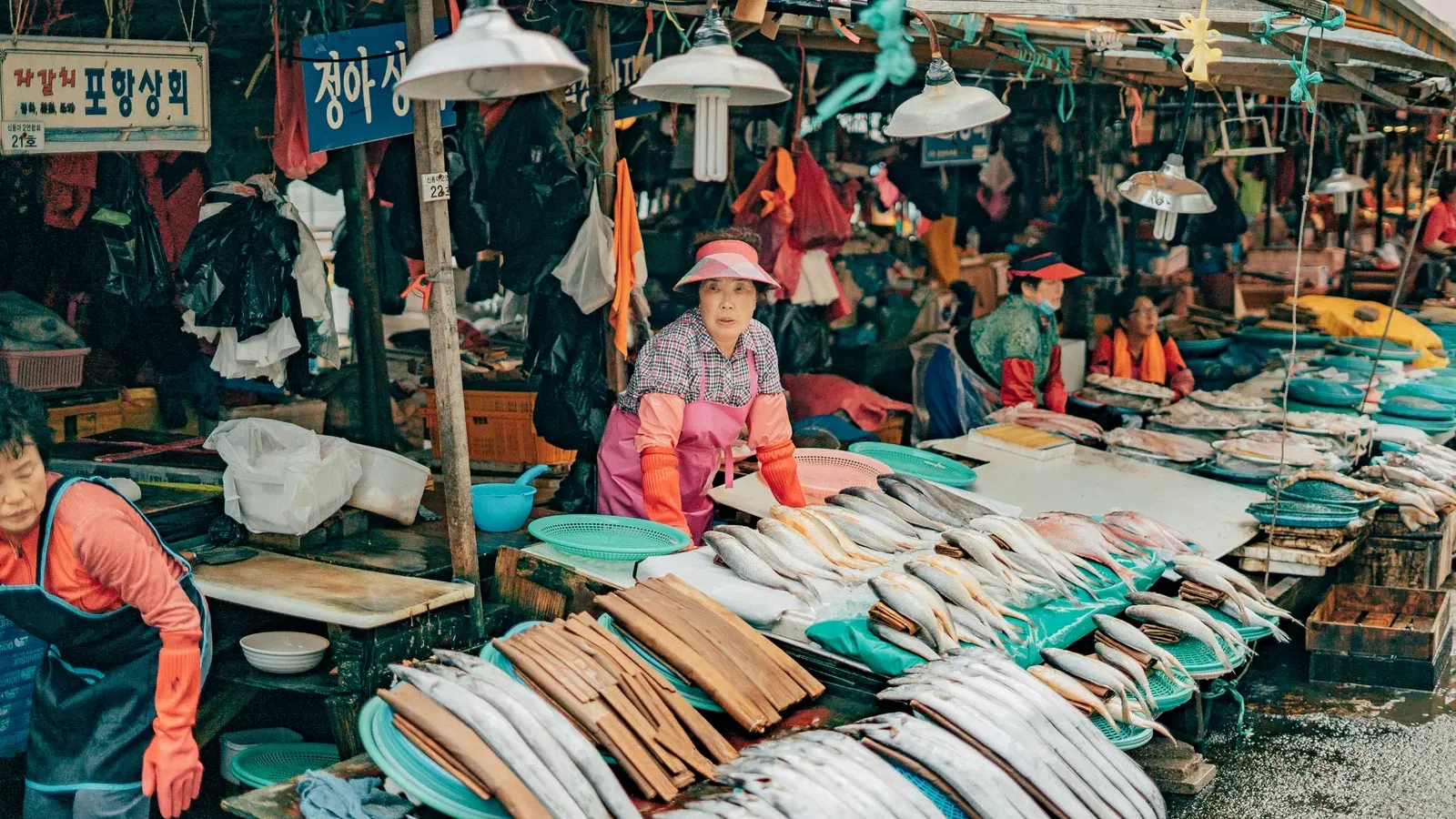 Fresh fish laid out at a Jagalchi Market stall with a vendor at work