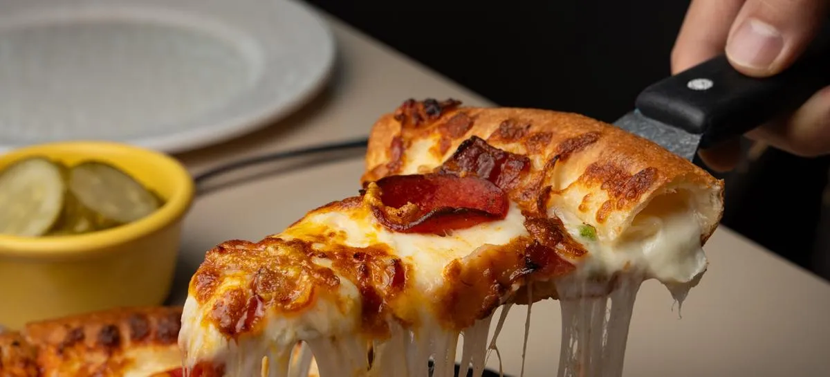A cheese-crust slice of Lee Jaemo pizza with melted cheese stretching