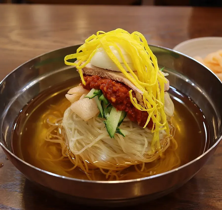 A bowl of milmyeon, Busan-style cold wheat noodles in tangy broth